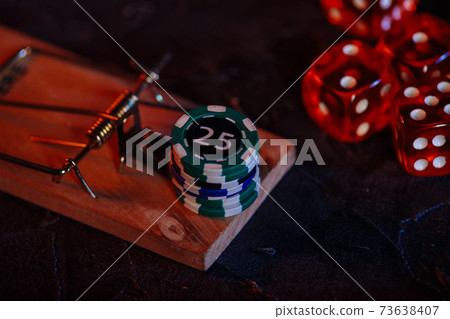 Mousetrap and casino chips on a grey background. Close-up Mousetrap and casino chips on a grey background. Close-up 73638407