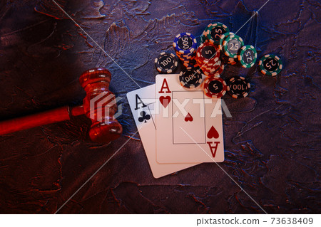 Law and rules for online casino concept, judge gavel with aces and playing chips on a grey background 73638409