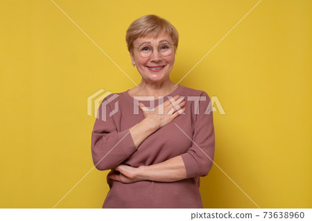 Aged caucasian lady with glasses posing to the camera smiling. Aged caucasian lady with glasses posing to the camera smiling. 73638960