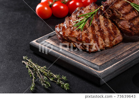 Fresh juicy delicious beef steak on a dark background 73639643