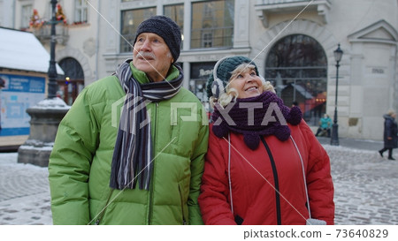 Elderly senior man woman tourists talking, gesturing in old city, holidays vacation trip concept 73640829