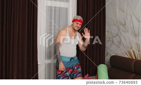Sportsman retro guy in funny sport clothes waving greeting with hand hello or bye, showing thumbs up 73640893