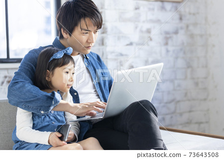 親子在客廳裡看個人電腦 73643508