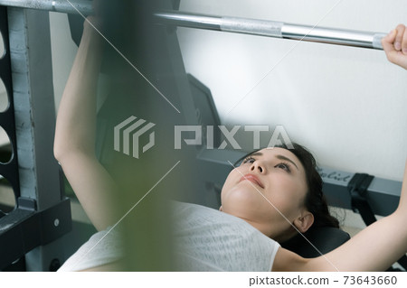 A woman doing muscle training at a gym A woman doing muscle training at a gym 73643660