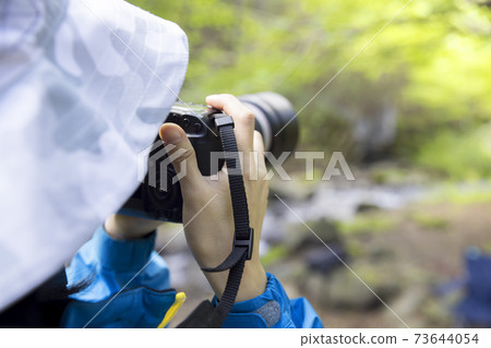 Trekking image of a woman taking pictures in the mountains 73644054