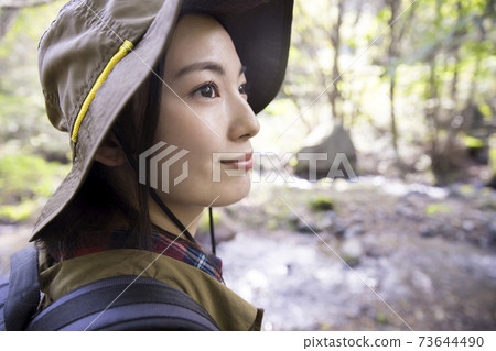 Trekking image of a woman walking on a mountain road Trekking image of a woman walking on a mountain road 73644490
