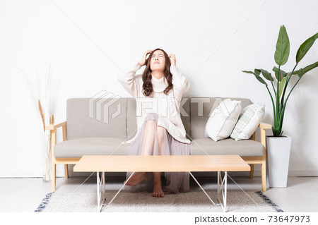 A troubled woman sitting on the sofa in the living room A troubled woman sitting on the sofa in the living room 73647973