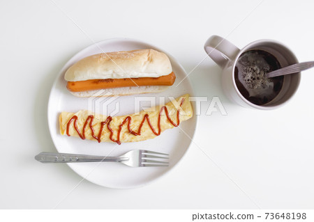Simple easy breakfast of omelette and sausage served on white table. Simple easy breakfast of omelette and sausage served on white table. 73648198