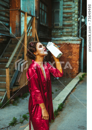 Girl in home clothes walking, wearing a mask, and with milk Girl in home clothes walking, wearing a mask, and with milk 73649498