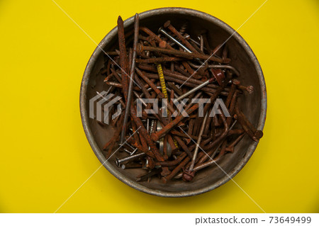 metal rusty nails on a yellow background metal rusty nails on a yellow background 73649499