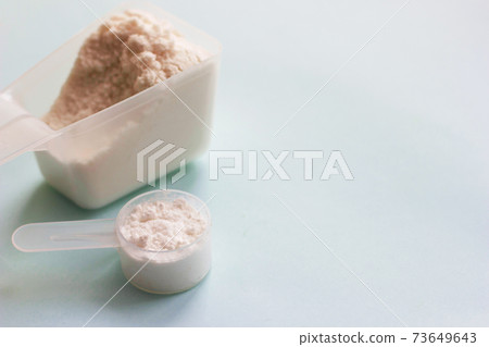 Fish collagen peptides powder on blue background. Fish collagen peptides powder on blue background. 73649643
