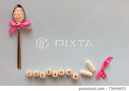 Fish collagen capsules and powder on grey background. Fish collagen capsules and powder on grey background. 73649653