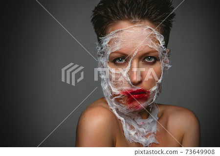 Feshion portrait, women with a mask on her face, horror, high fashion, blood, bandage 73649908
