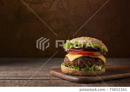 Delicious meat burger on rustic and wooden background. Place for text. Delicious meat burger on rustic and wooden background. Place for text. 73652161