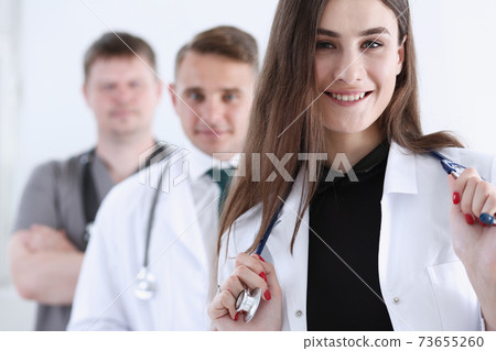Group of medics proudly posing in row and looking in camera Group of medics proudly posing in row and looking in camera 73655260