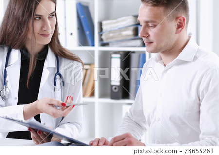 Female doctor hand hold silver pen and showing pad 73655261
