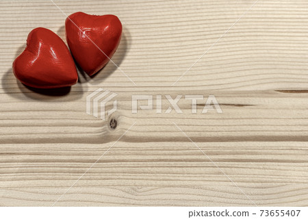 Couple of Wooden Red Hearts on a Light Wooden Background Couple of Wooden Red Hearts on a Light Wooden Background 73655407