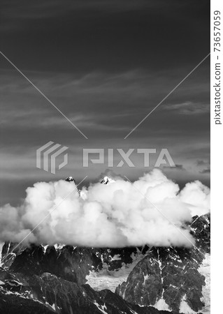 High rocky mountains with snow and glacier hidden in clouds 73657059