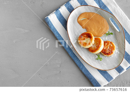 Russian cheesecakes served on plate with sauce Russian cheesecakes served on plate with sauce 73657616