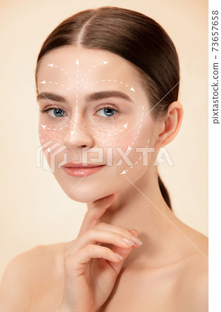 Beautiful female face with lifting up arrows isolated on studio background Beautiful female face with lifting up arrows isolated on studio background 73657658