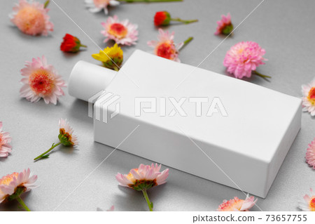 Bottle of fragrance surrounded by flower buds 73657755