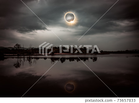 Scientific natural phenomenon. Total solar eclipse with diamond ring effect glowing on sky. Scientific natural phenomenon. Total solar eclipse with diamond ring effect glowing on sky. 73657833