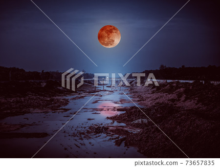 Landscape of night sky with many stars and blood moon. 73657835