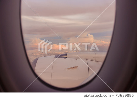 Beautiful view of sunset or sunrise clouds and sky from airplane window Beautiful view of sunset or sunrise clouds and sky from airplane window 73659896