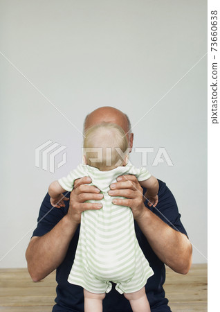 Grandfather Holding Up Grandchild Grandfather Holding Up Grandchild 73660638