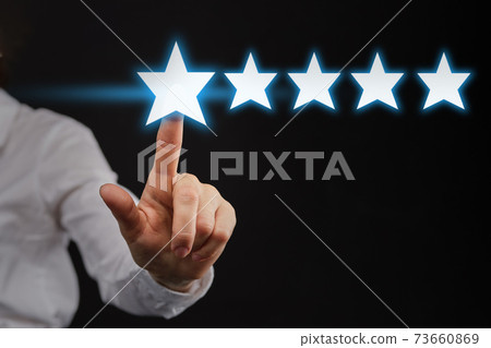 The hand points to five 5 stars as a concept of top rating or rating. The hand points to five 5 stars as a concept of top rating or rating. 73660869