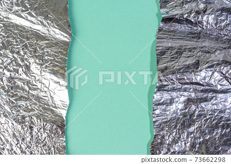 torn pieces of foil on a green background 73662298