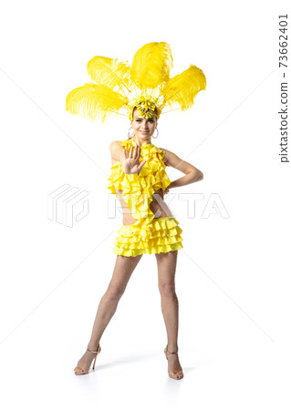 Beautiful young woman in carnival, stylish masquerade costume with feathers dancing on white studio background. 73662401