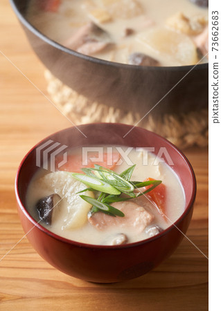Salmon and root vegetable soup served in a bowl 73662683