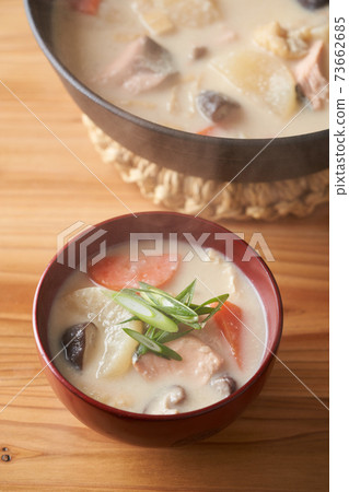 Salmon and root vegetable soup served in a bowl 73662685