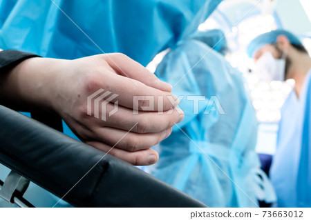 Hand of a patient lying on the operating table.  73663012