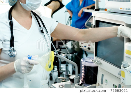 A doctor urgently prepares artificial lung ventilation equipment for a patient with a coronavirus A doctor urgently prepares artificial lung ventilation equipment for a patient with a coronavirus 73663031