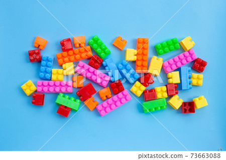 Plastic building blocks on blue background. Plastic building blocks on blue background. 73663088