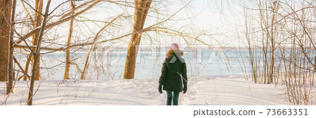 Winter forest walk active woman walking in snow trail outdoor nature panoramic banner. Healthy lifestyle outdoors leisure activity panorama 73663351