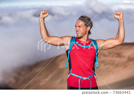 Fitness achievement fit athlete man screaming with fists up in the air winner arms up. Success in sport hiker on summit of mountain - goal challenge 73663441