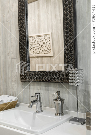 Close-up of a washbasin with a faucet in the bathroom Close-up of a washbasin with a faucet in the bathroom 73664413