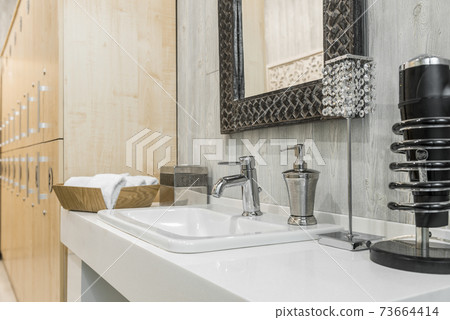 Close-up of a washbasin with a faucet in the bathroom Close-up of a washbasin with a faucet in the bathroom 73664414
