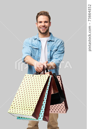Portrait of a handsome young man with shopping bags 73664852