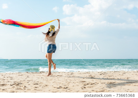 Summer Vacation. Lifestyle woman walking and jumping relax happy on beach Summer Vacation. Lifestyle woman walking and jumping relax happy on beach 73665368