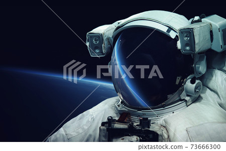 Astronaut at spacewalk. Cosmic art, science fiction wallpaper. Reflection in spacesuit vizor. Billions of galaxies in the universe. Elements of this image furnished by NASA Astronaut at spacewalk. Cosmic art, science fiction wallpaper. Reflection in spacesuit vizor. Billions of galaxies in the universe. Elements of this image furnished by NASA 73666300