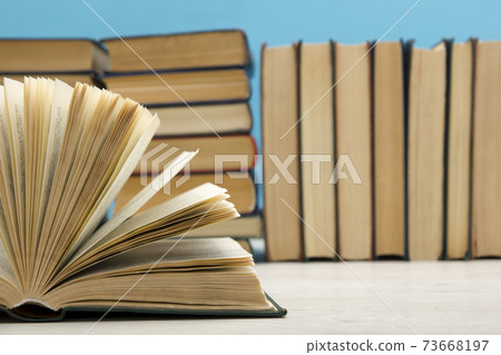 Composition with vintage old hardback books, diary, fanned pages on wooden deck table and red background. Books stacking. Back to school. Copy Space. Education background. 73668197