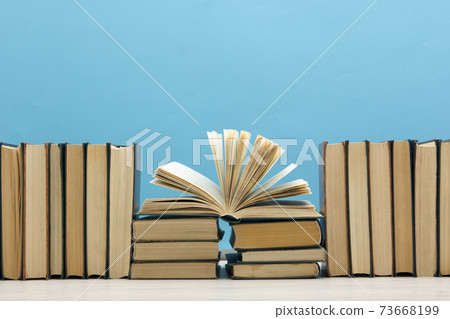 Composition with vintage old hardback books, diary, fanned pages on wooden deck table and red background. Books stacking. Back to school. Copy Space. Education background. Composition with vintage old hardback books, diary, fanned pages on wooden deck table and red background. Books stacking. Back to school. Copy Space. Education background. 73668199