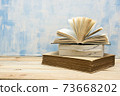 Composition with vintage old hardback books, diary, fanned pages on wooden deck table and red background. Books stacking. Back to school. Copy Space. Education background. 73668202