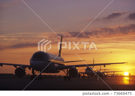 Planes Sitting on Tarmac at Sunset 73668475