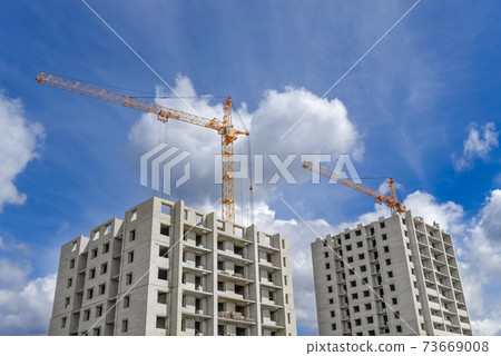 Multi-storey houses under construction and high-rise crane 73669008