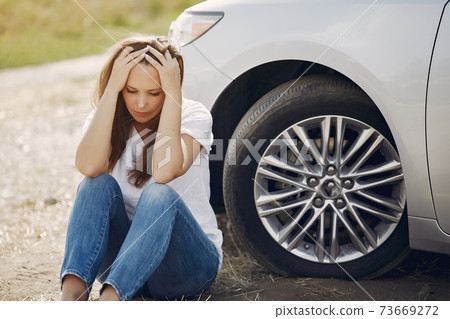 Woman near broken car call for help 73669272